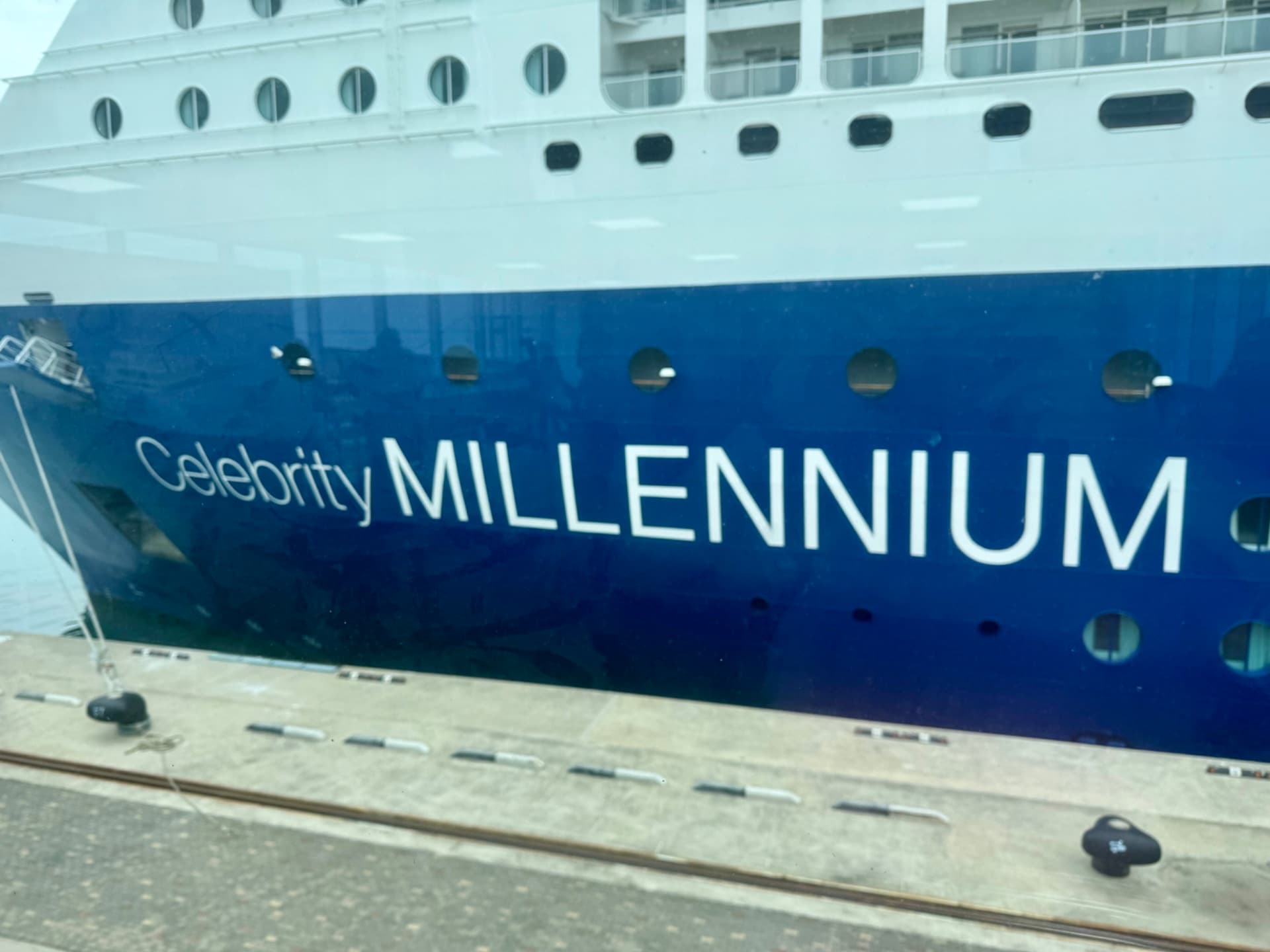 Celebrity Millennium cruise ship docked at port, showing the blue hull with white superstructure and portholes.