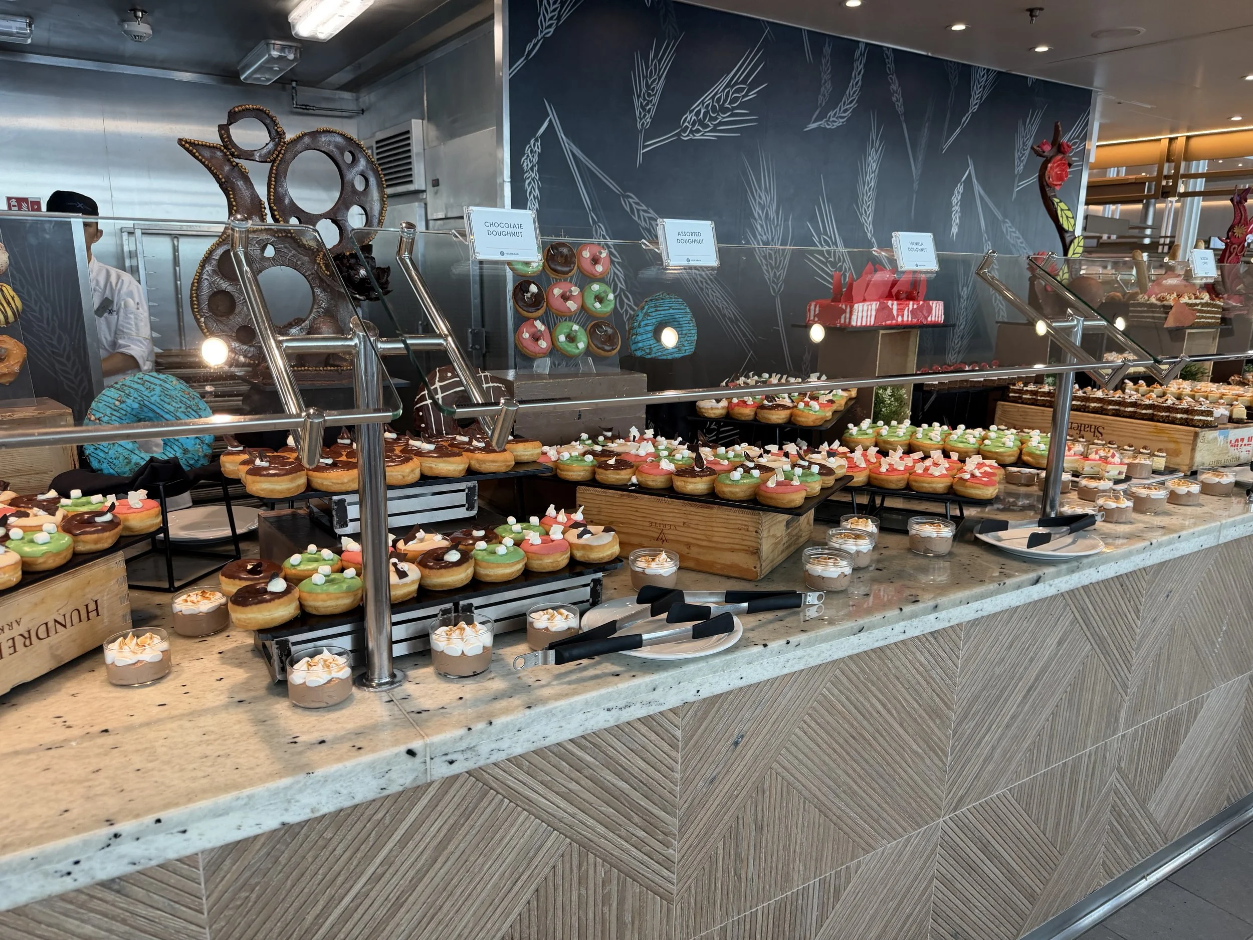 Bakery display case with decorated donuts and pastries onboard cruise ship