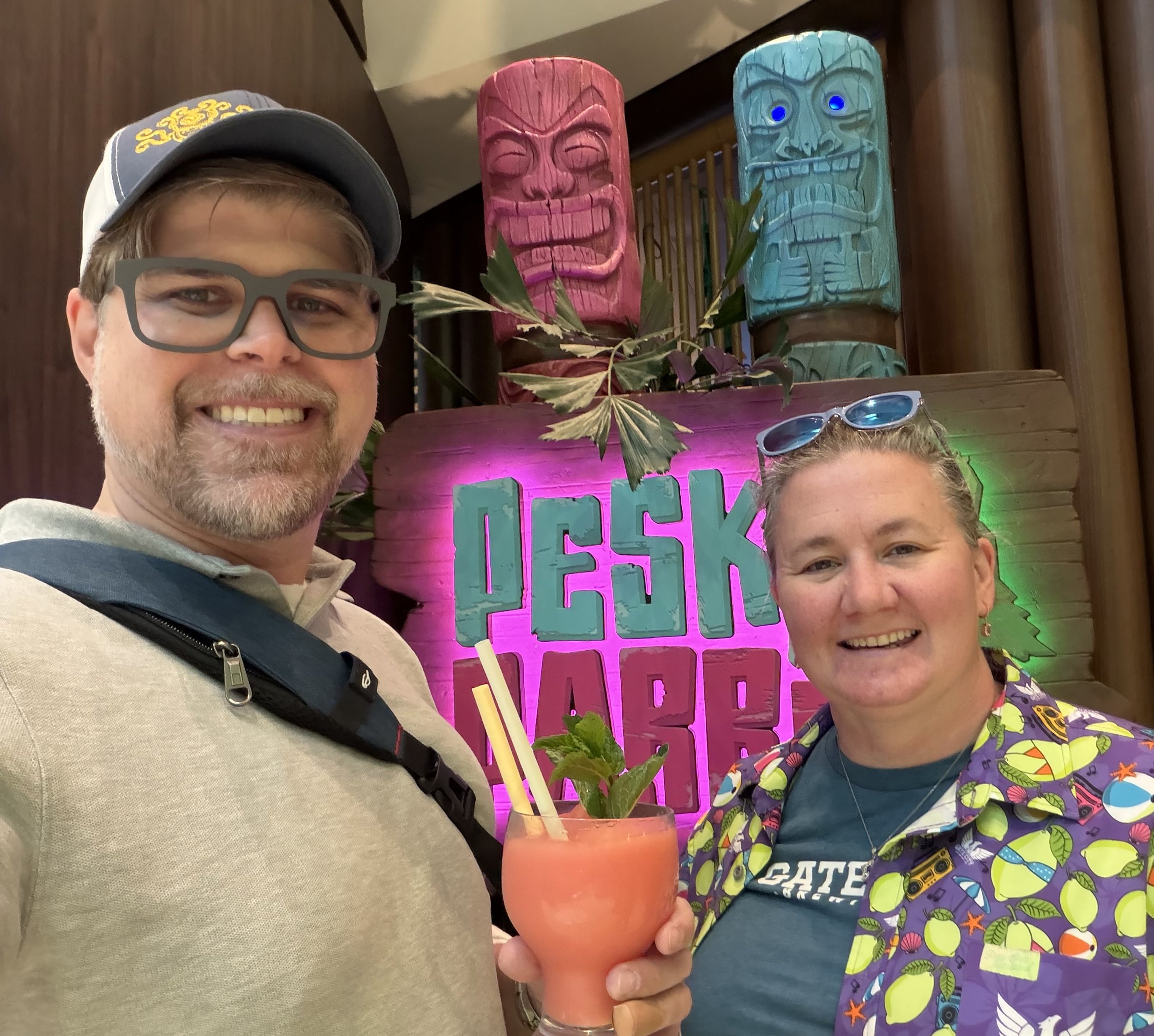 Man and woman at Desk Bar tiki bar with tropical drink