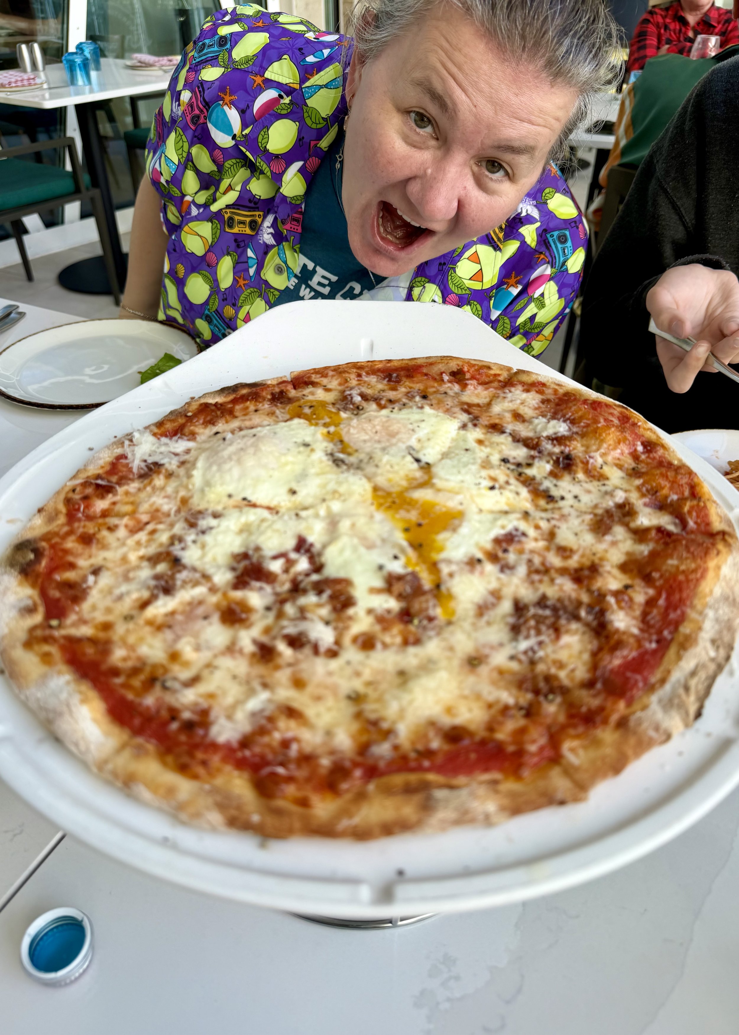 Woman enjoys pizza at casual dining restaurant on cruise ship