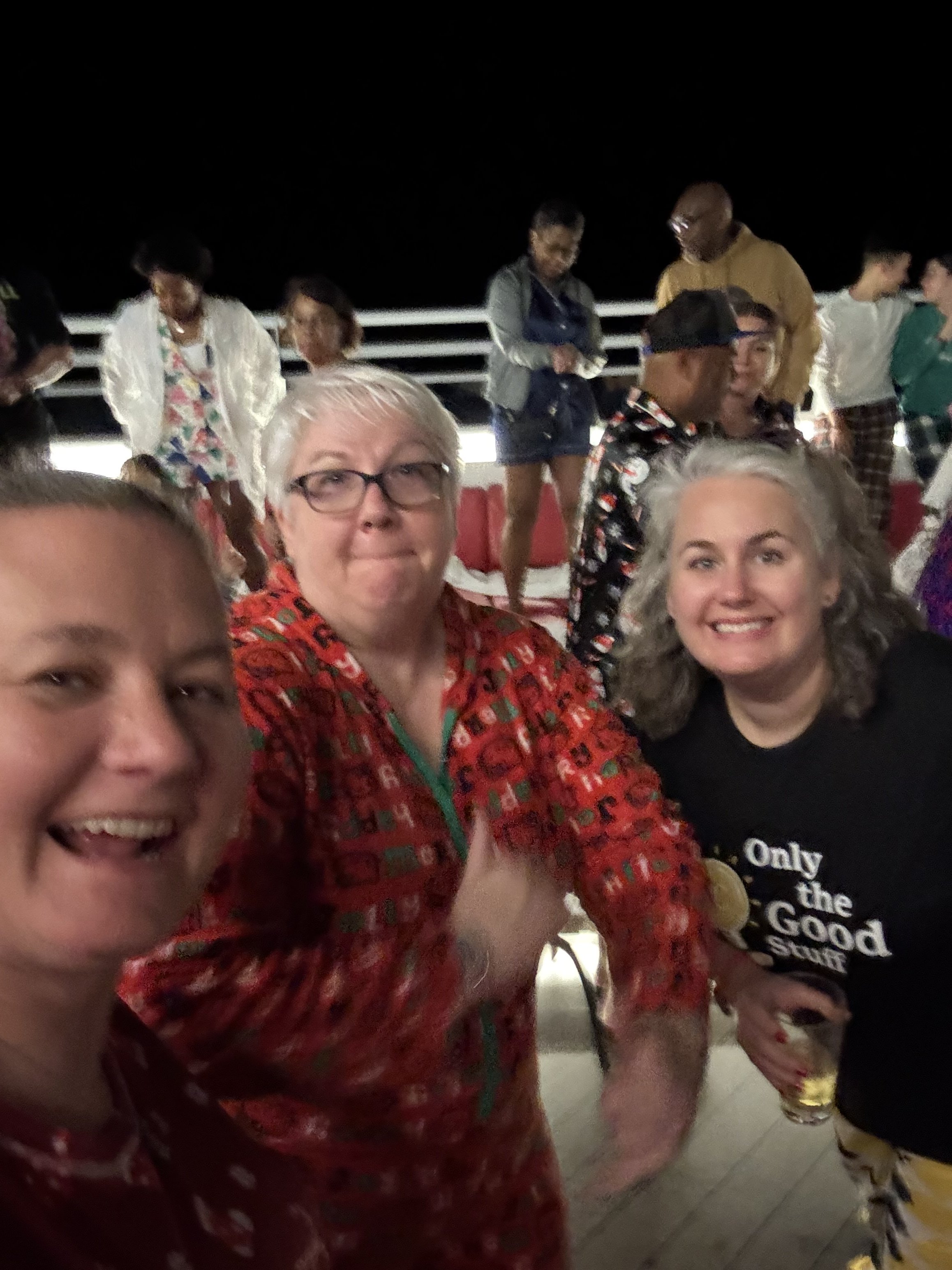 Group of women smiling on cruise ship deck at night