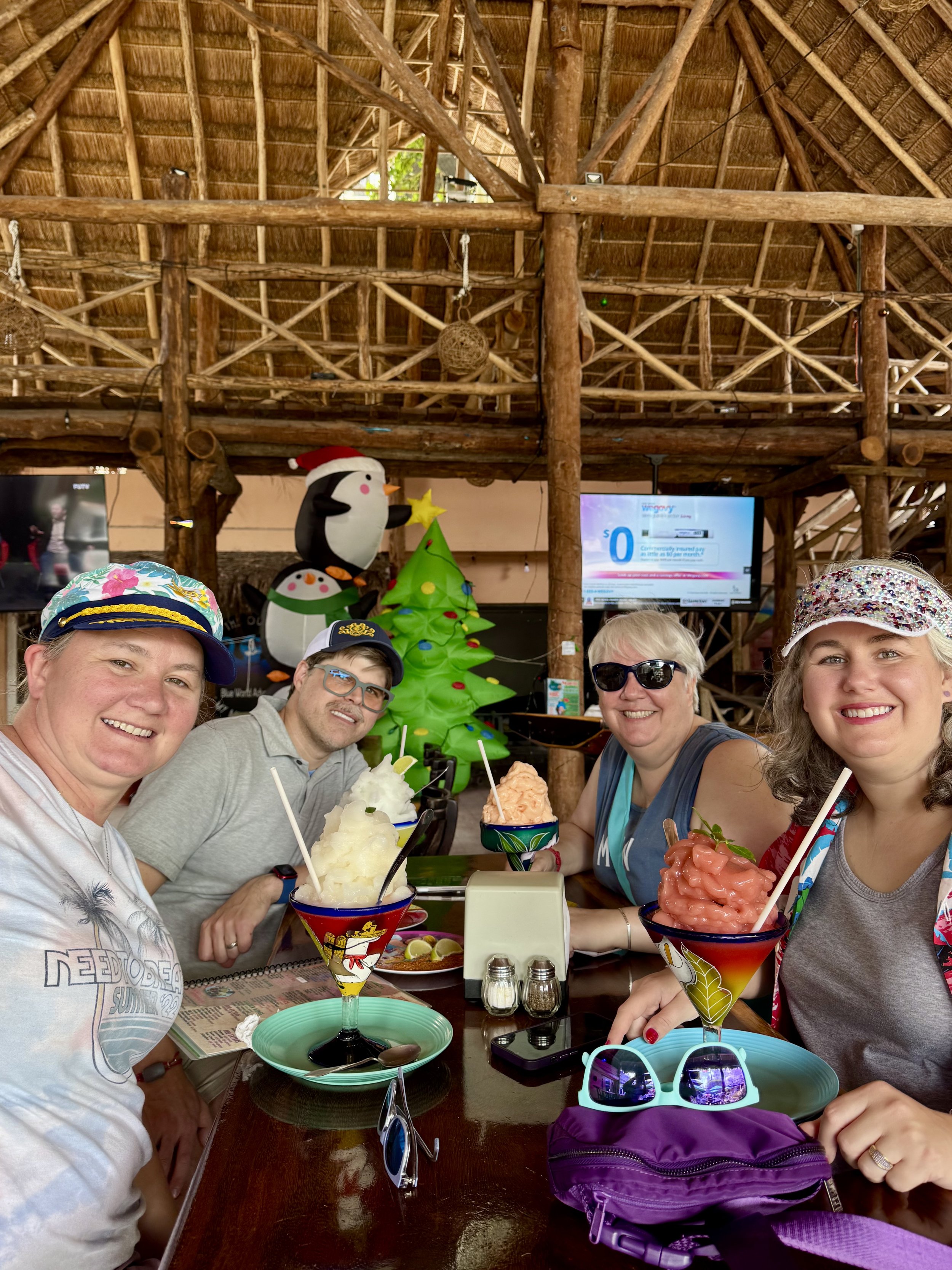 Group enjoying tropical cocktails at rustic tiki bar during cruise