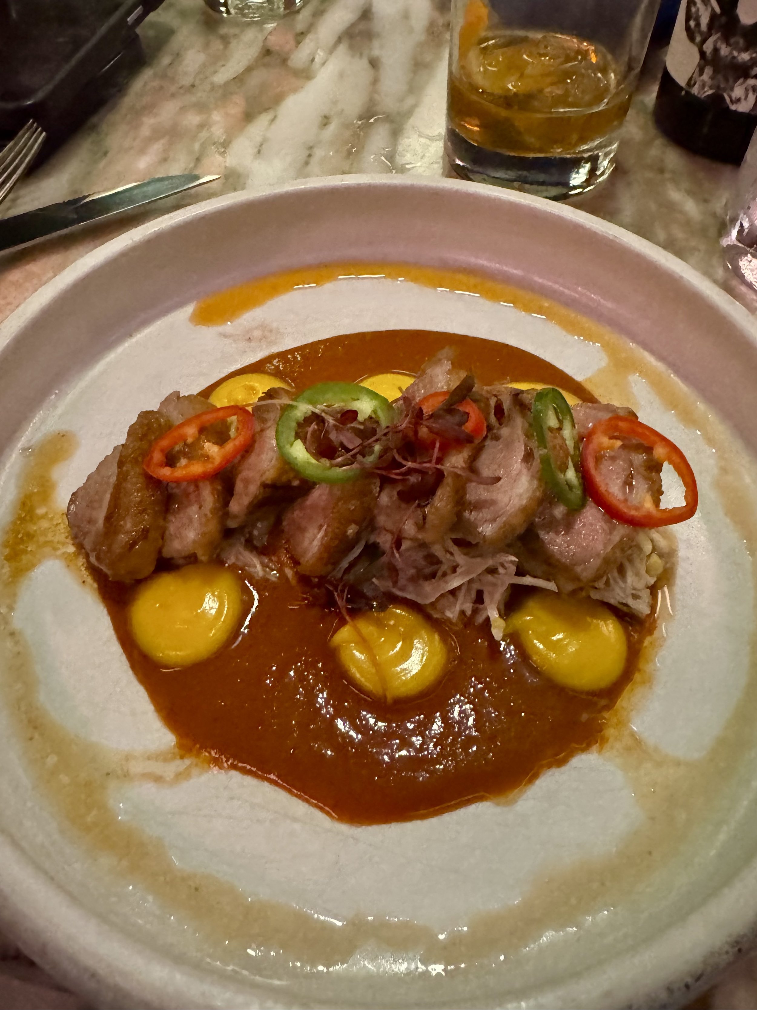 Plated duck with olives and peppers, fine dining restaurant