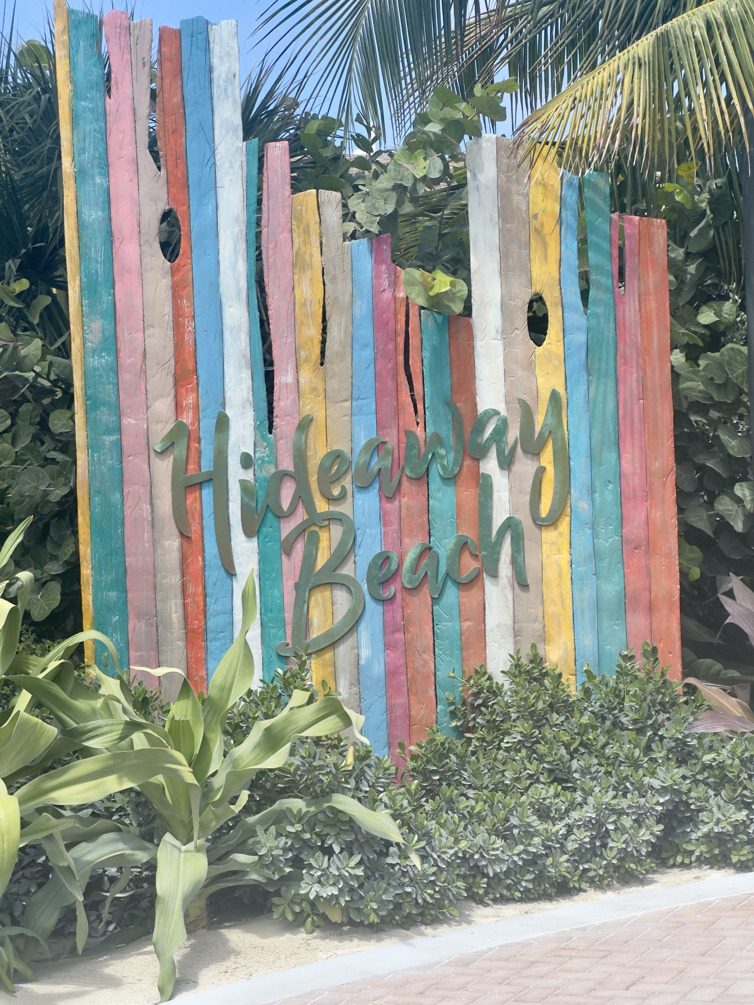 Colorful beach welcome sign with painted wooden slats