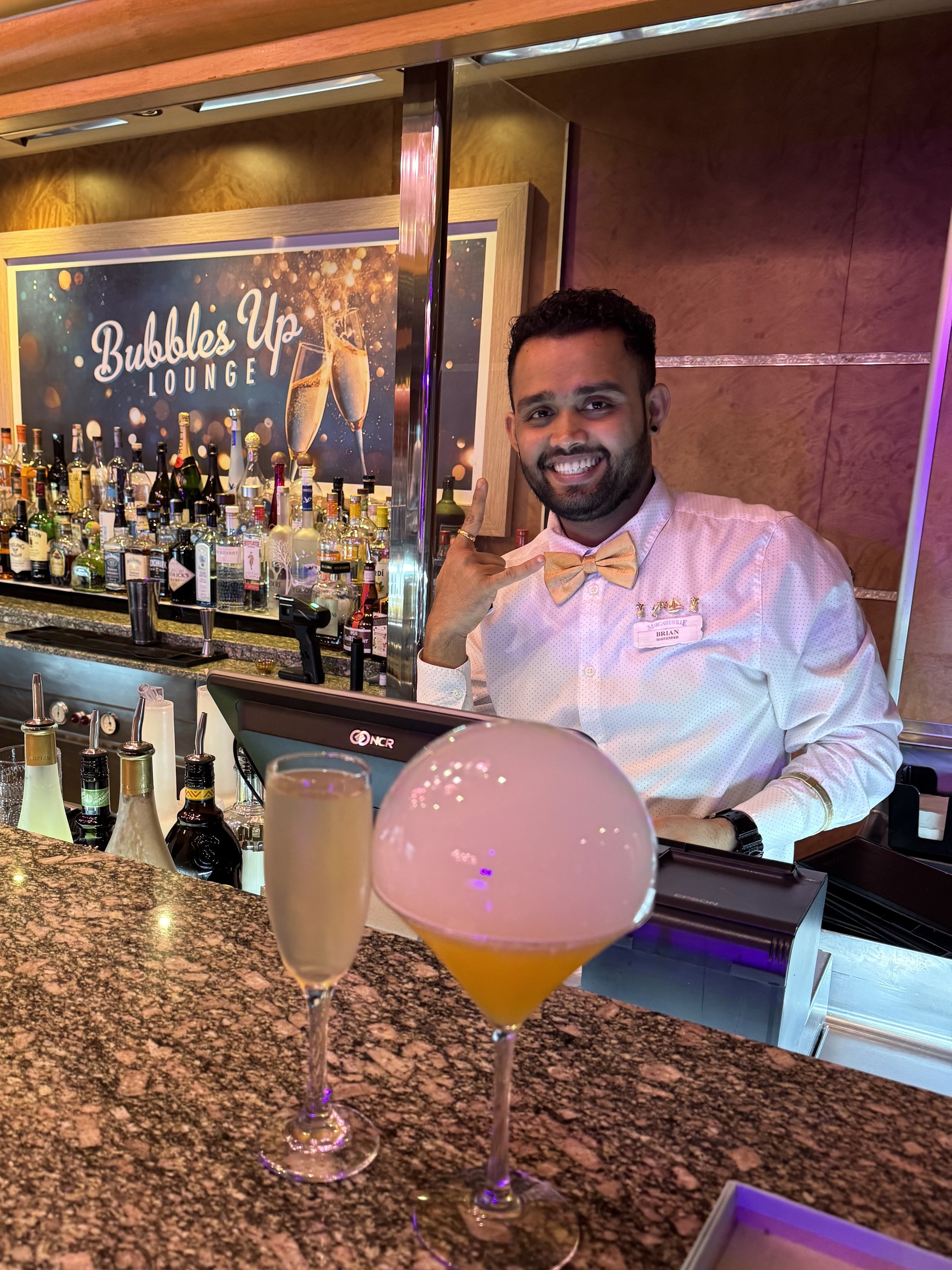 Bartender smiling at Bubbles Up Lounge cocktail bar with champagne drinks