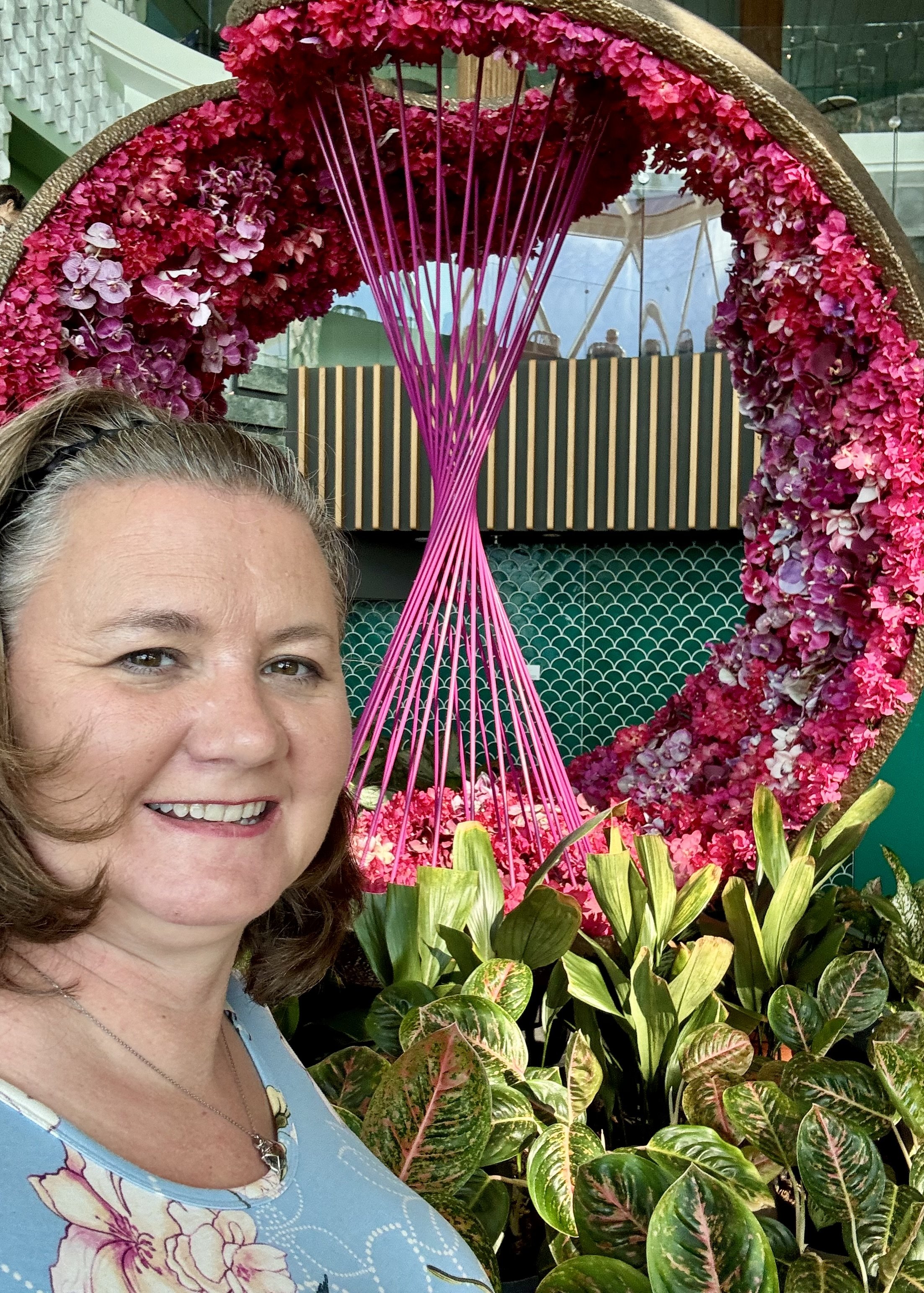 Woman posing with vibrant pink floral arch display