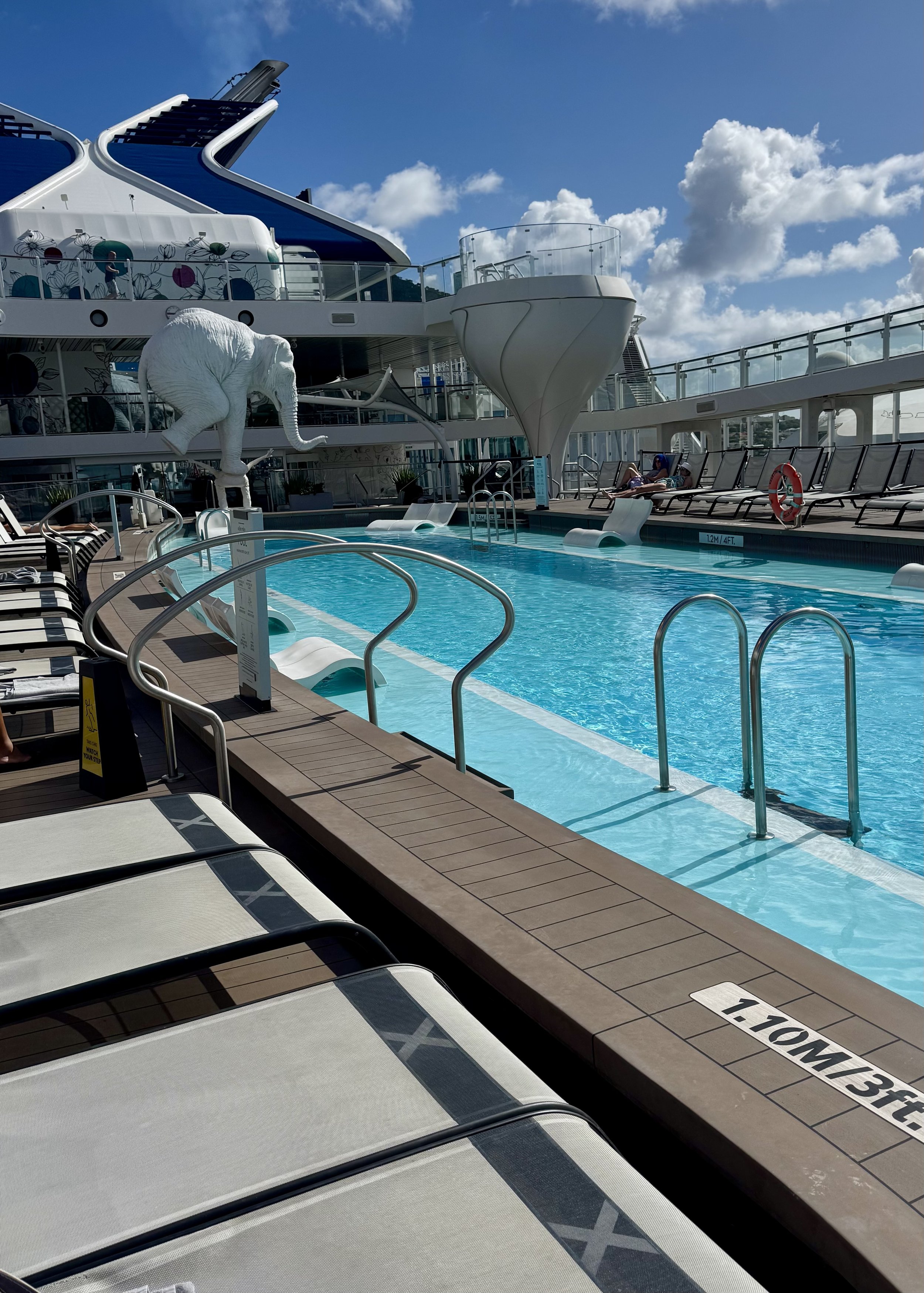 Cruise ship pool deck with loungers and waterslide